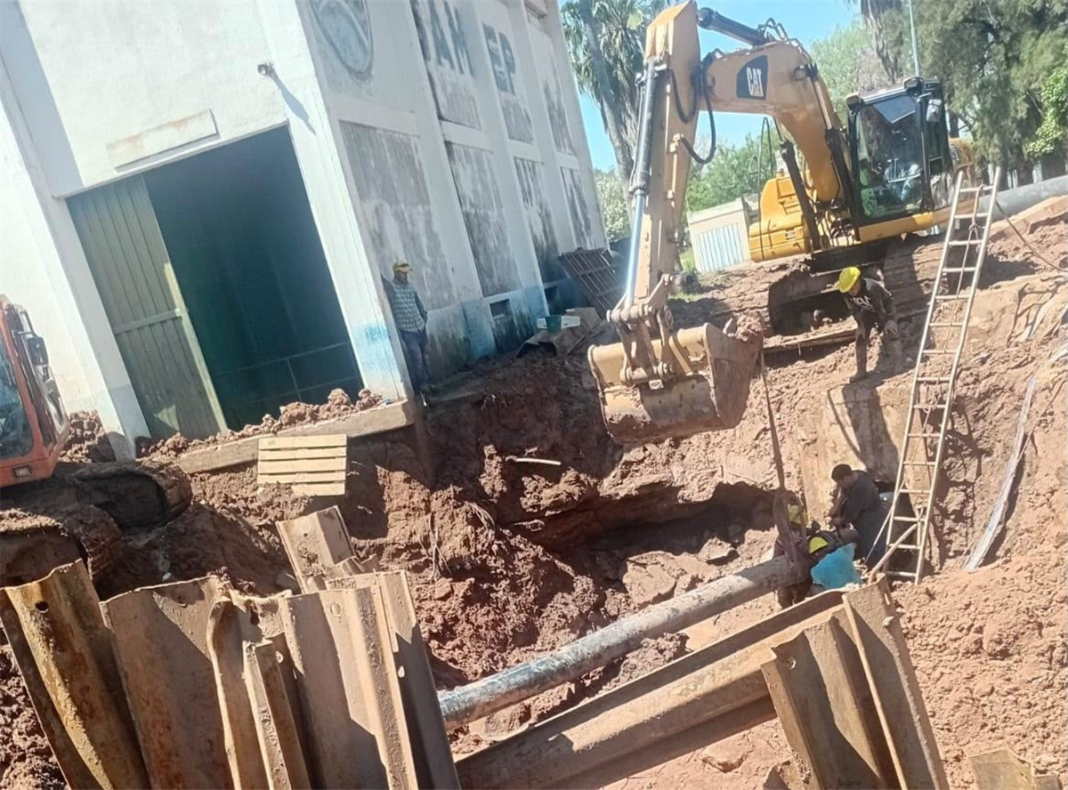 Retroexcavadora y operarios intervienen una cañería del acueducto en una excavación