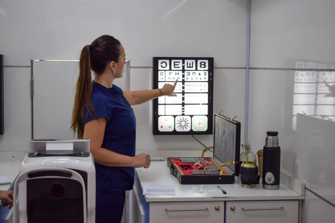Profesional realiza un control oftalmológico con cartilla visual durante un operativo de salud visual.