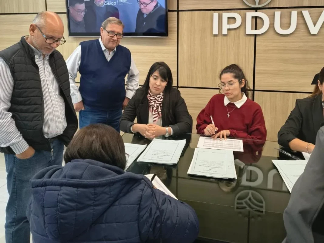 Autoridades y familias durante la firma de escrituras del IPDUV