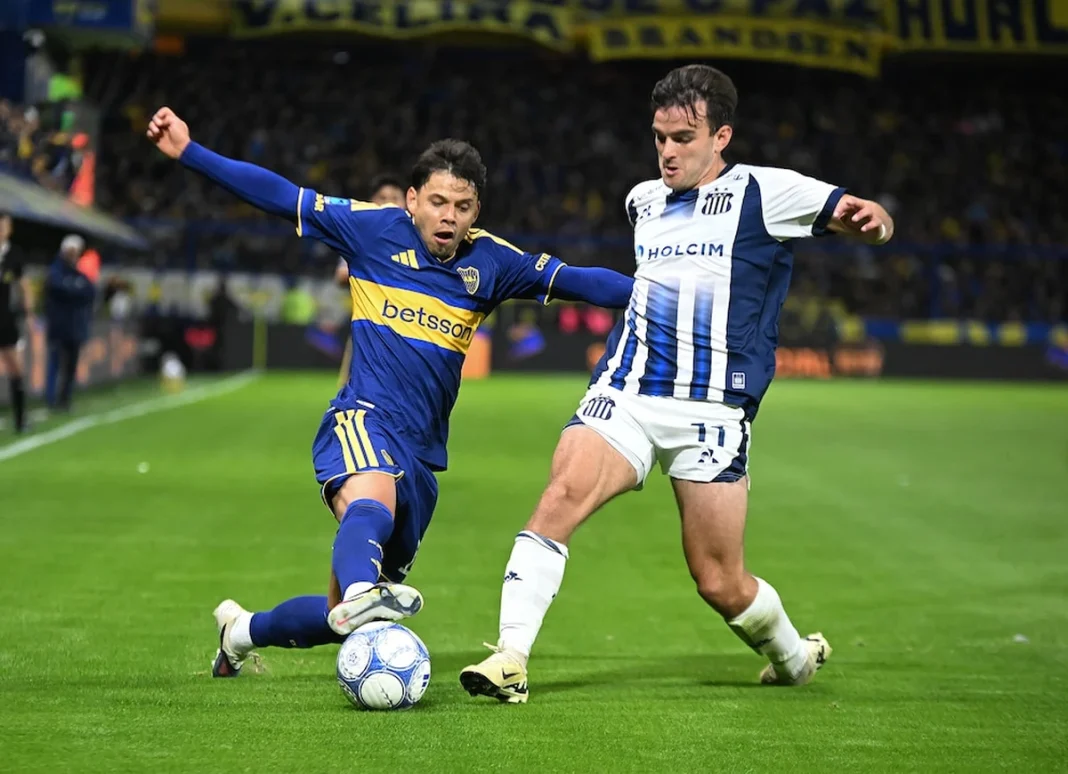 Ángel Romero disputa la pelota con un jugador de Talleres en la Bombonera