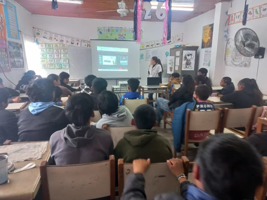 Estudiantes observan una clase virtual proyectada en un aula de primaria chaqueña.