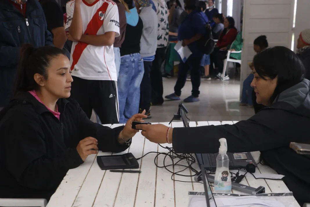 Una trabajadora atiende a una vecina en una mesa durante el operativo RES.