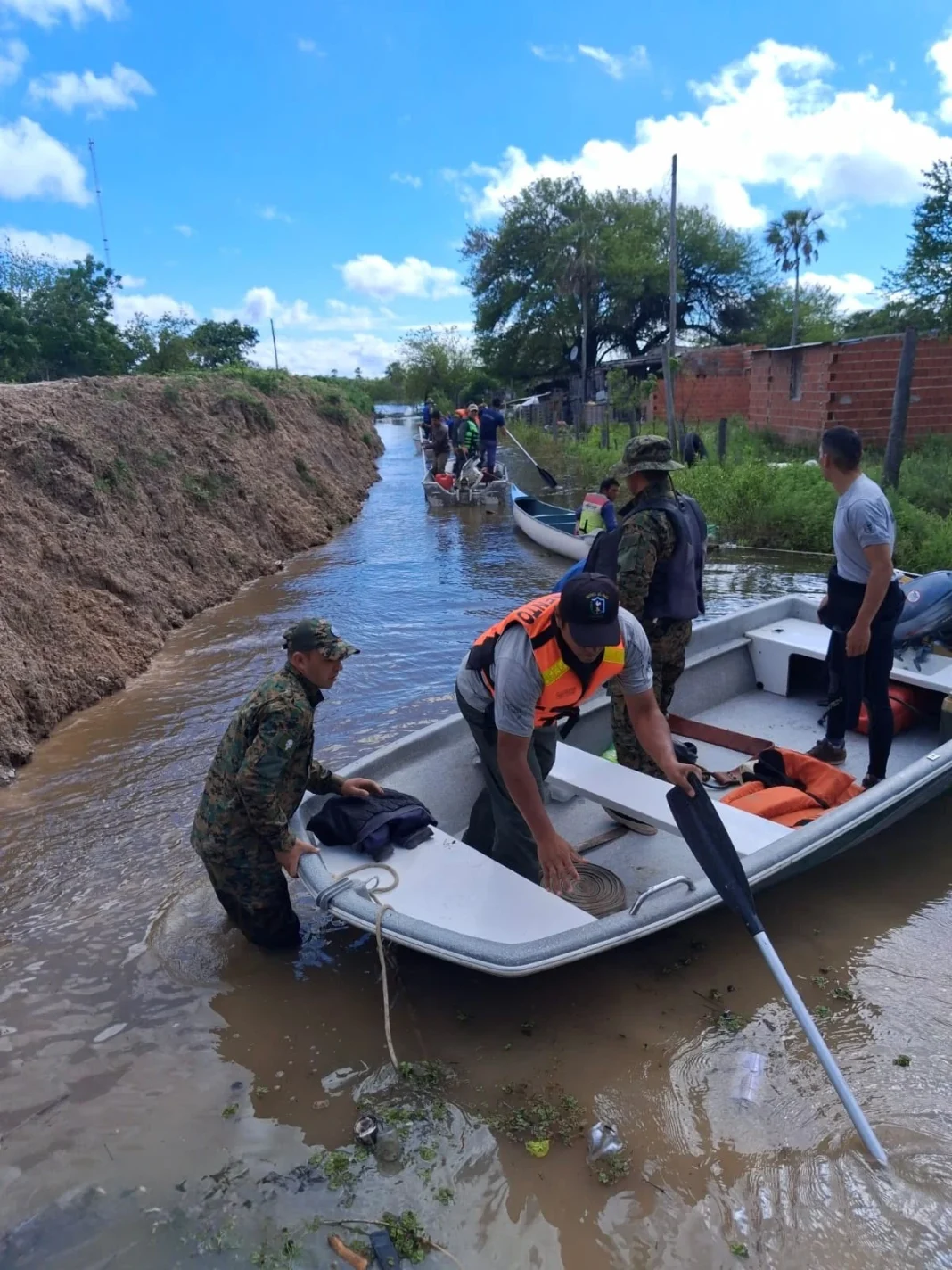 Integrantes del operativo trabajan junto a una embarcación en una zona inundada de Puerto Vilelas.